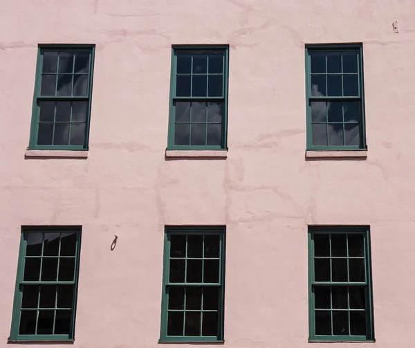 Zelená okna v růžové štuky — Stock fotografie