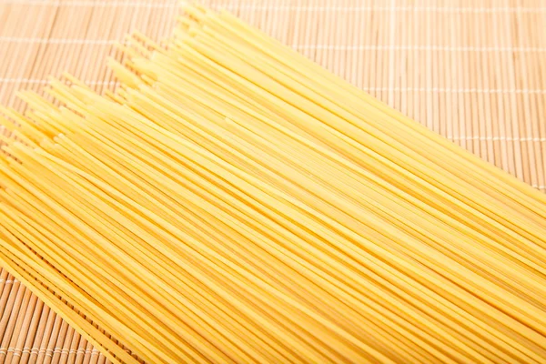 Spaghetti secchi su tappetino di bambù — Foto Stock