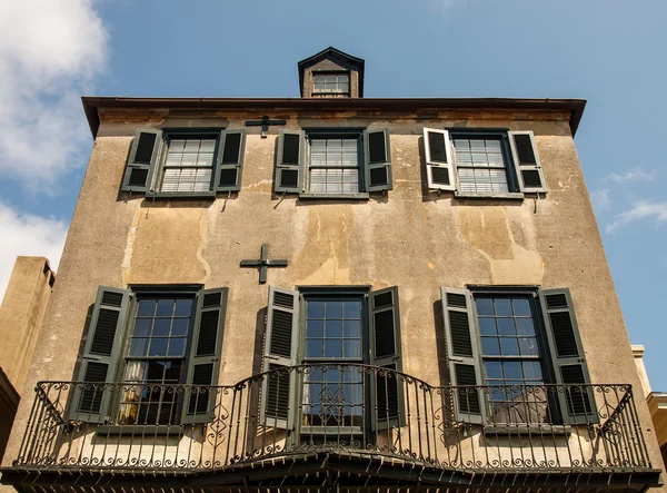 Stary tynk budynek czarny okiennice i balkonem — Zdjęcie stockowe