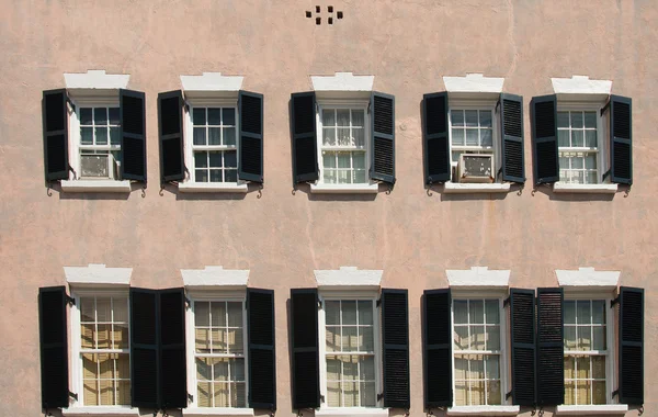 Persianas negras en ventanas blancas en el edificio Stucco — Foto de Stock