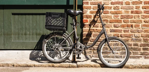 Bicicleta negra por pared de ladrillo —  Fotos de Stock