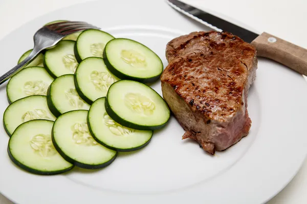 Steak a okurky s nožem a vidličkou — Stock fotografie