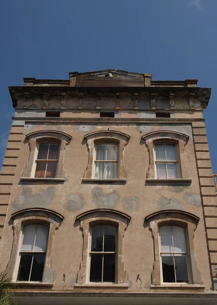 Alter rissiger Putzbau mit sechs Fenstern — Stockfoto