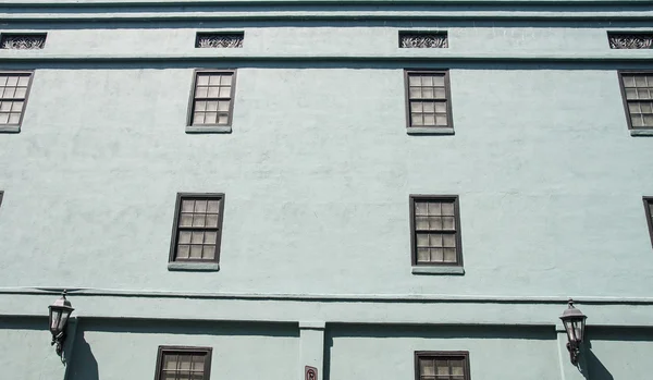 Μαύρο παράθυρα στο παλιό πράσινο Στόκος τοίχο — Φωτογραφία Αρχείου