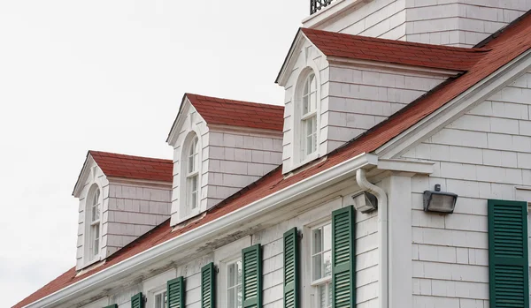 Takkupor på röda tak med gröna fönsterluckor — Stockfoto