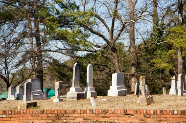 tuğla duvarın ötesinde eski mezar taşları