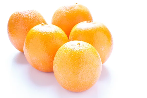 Cinco naranjas en luz de ventana sobre blanco — Foto de Stock