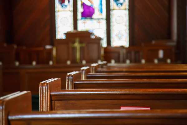 Kirchenbänke mit Glasmalerei jenseits der Kanzel Stockbild