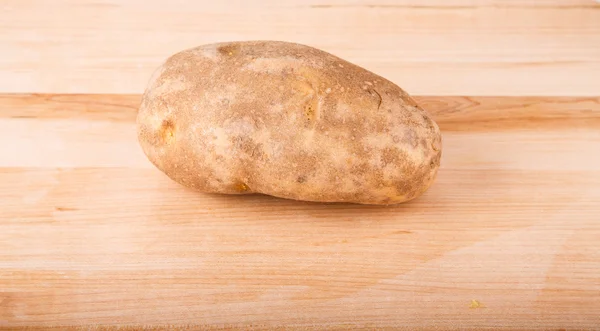 Ganze Kartoffel auf Holzschneidebrett — Stockfoto