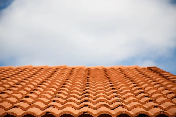 Techo de azulejos de arcilla roja bajo cielos nublados — Foto de Stock