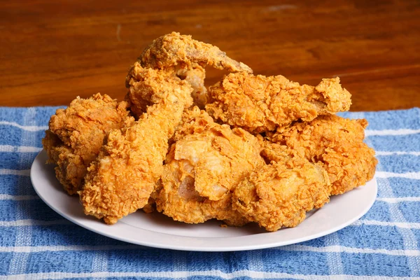 Assiette de poulet frit sur serviette à carreaux bleue — Photo