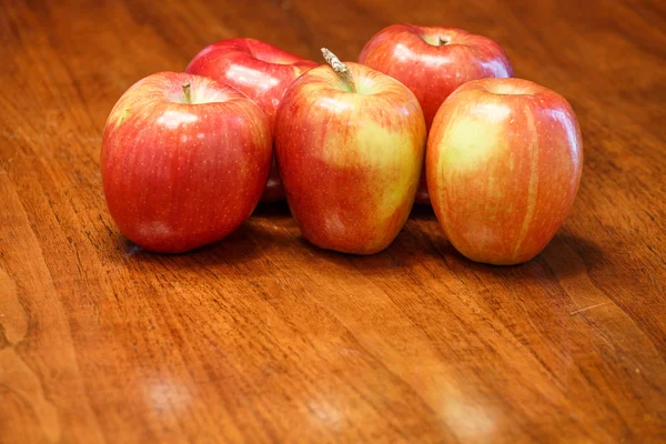 Cinco manzanas en mesa de madera con espacio delante — Foto de Stock