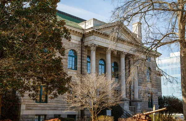 Ancien palais de justice en pierre parmi les arbres — Photo