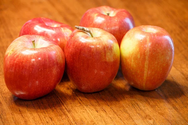 Cinco manzanas rojas maduras en una mesa de madera —  Fotos de Stock