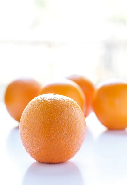 Апельсины в окне свет на белом — стоковое фото
