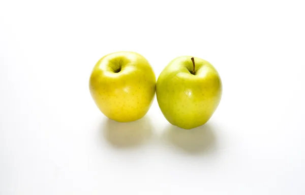 Dos manzanas deliciosas doradas en contador blanco —  Fotos de Stock