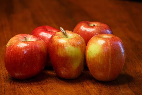 Cinco manzanas rojas en mesa de madera —  Fotos de Stock