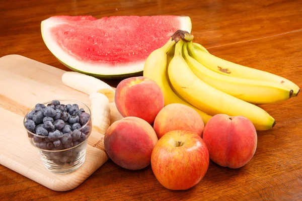 Hela och skär frukt på bord — Stockfoto