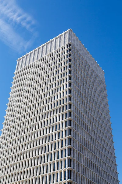Bílý konkrétní věž s úzkými modrými okny — Stock fotografie