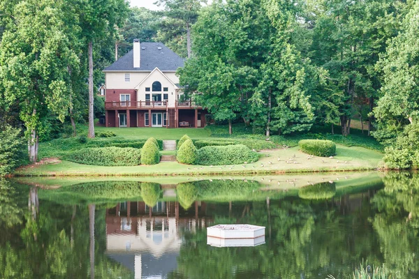 Huis in voorjaar meer weerspiegeld — Stockfoto