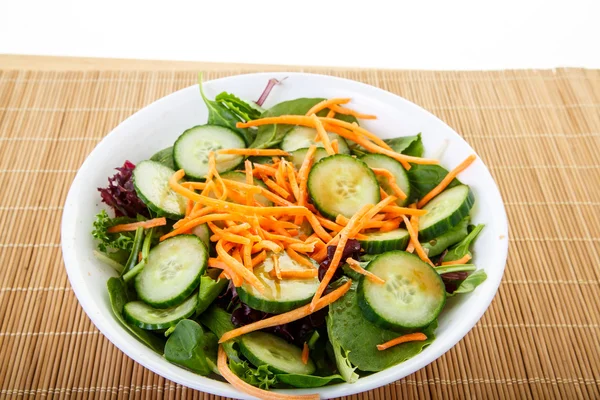 Plantaardige salade in witte kom op bamboe mat — Stockfoto