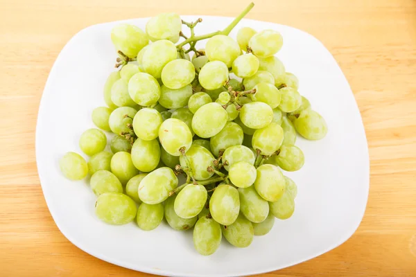 Vita kärnfria druvor på vit platta — Stockfoto