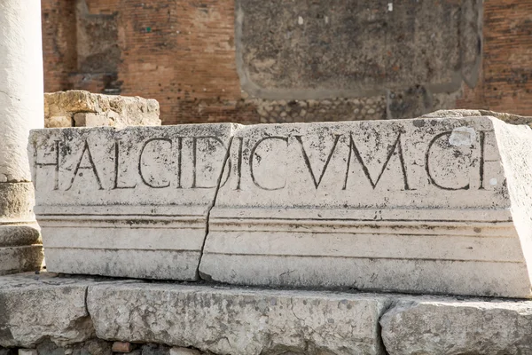 Lateinische Buchstaben auf Steinmauer — Stockfoto