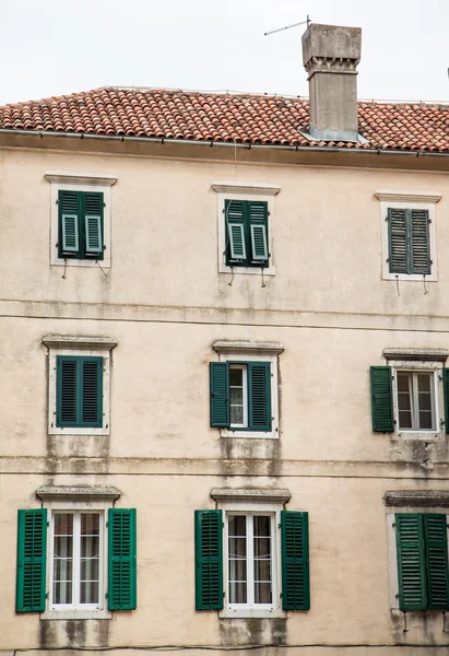 Gammal byggnad i kotor med gröna fönsterluckor — Stockfoto