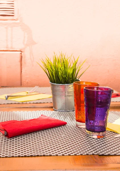 Μοβ και πορτοκαλί ποτήρια στο τραπέζι — Φωτογραφία Αρχείου