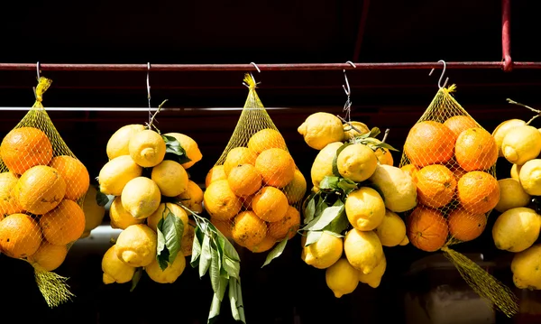 Naranjas y limones colgando en el mercado — Foto de Stock