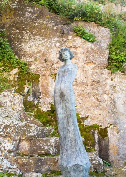 Statue des Mädchens an der Steinmauer — Stockfoto