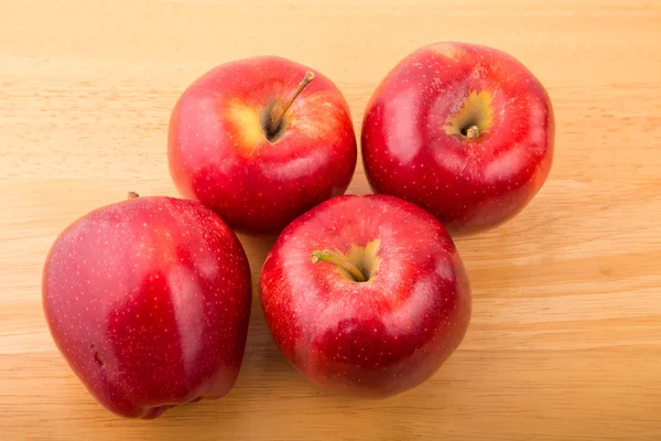Cuatro manzanas rojas en la mesa de madera de arriba —  Fotos de Stock