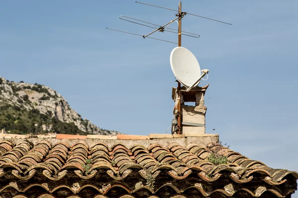 Old TV Antenna and Modern Dish on Roof