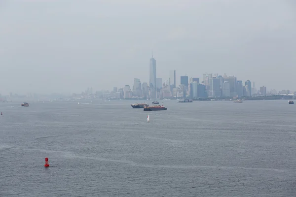 Zeilboot door vrachtschepen in de haven van new york — Stockfoto