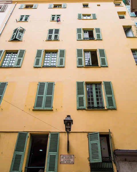 Lampada nera e persiane verdi su intonaco giallo — Foto Stock