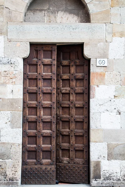 Старая деревянная дверь с железными прутьями — стоковое фото