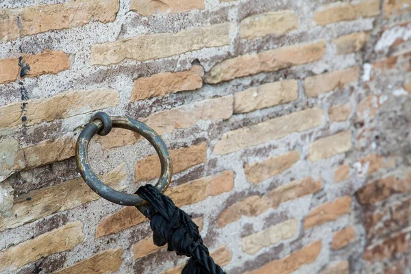 Black Rope on Old Brass Ring and Brick Wall — Stock Photo, Image