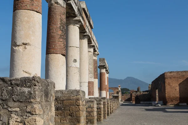 Rad kolonner i Pompeji med vesuvius i bakgrunden — Stockfoto