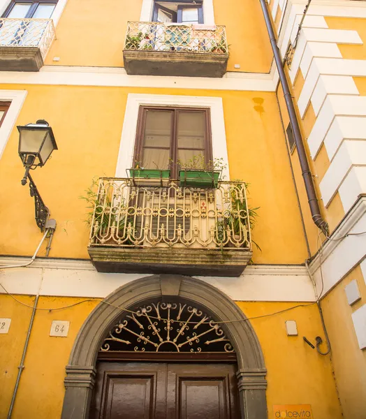 Fioriere su balconi di ferro su intonaco giallo — Foto Stock