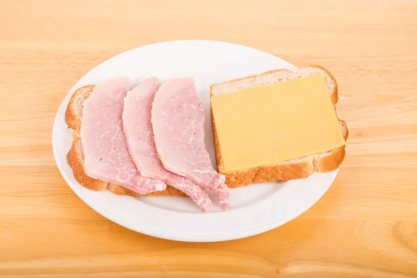 Sandwich affettato di prosciutto e formaggio su piatto bianco — Foto Stock