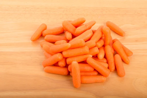 Куча детской моркови на деревянном столе — стоковое фото