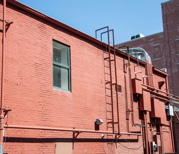 Metalen ladder op oude rode bakstenen — Stockfoto