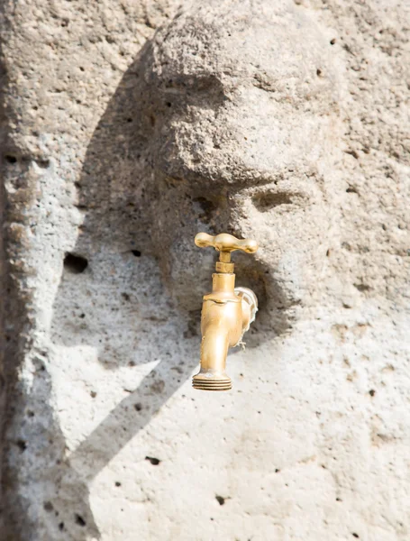 Brass Faucet in Pompeii Stone Face — Stock Photo, Image