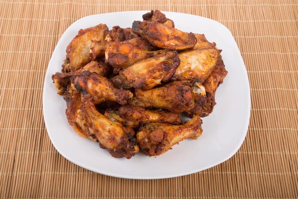 Mesquite Barbecue Chicken Wings on White Plate and Bamboo Mat — Stock Photo, Image