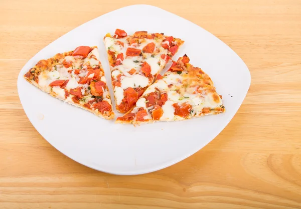 Três fatias de pizza de tomate na placa branca — Fotografia de Stock