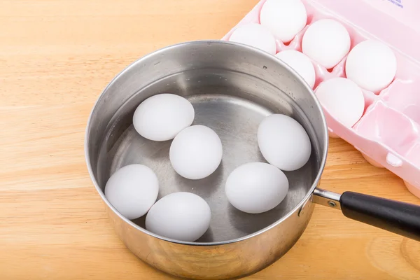 Eggs in a Saucepan and a carton — Stock Photo, Image