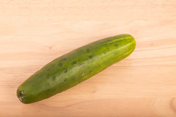 Pepino inteiro na mesa de madeira — Fotografia de Stock