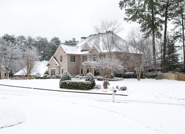 Grote bakstenen huis in de sneeuw — Stockfoto