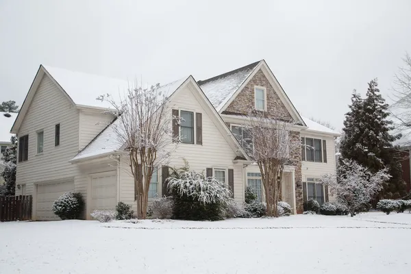 サイディングと雪の中で石造りの家 — ストック写真