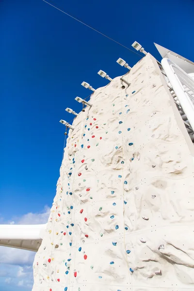 Parede de escalada sob céu azul com sino no topo — Fotografia de Stock